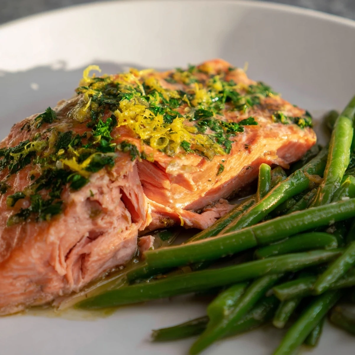 Golden-baked Sheet Pan Salmon and green beans rest on a sheet pan, glistening with lemon garlic herb marinade and ready to serve.
