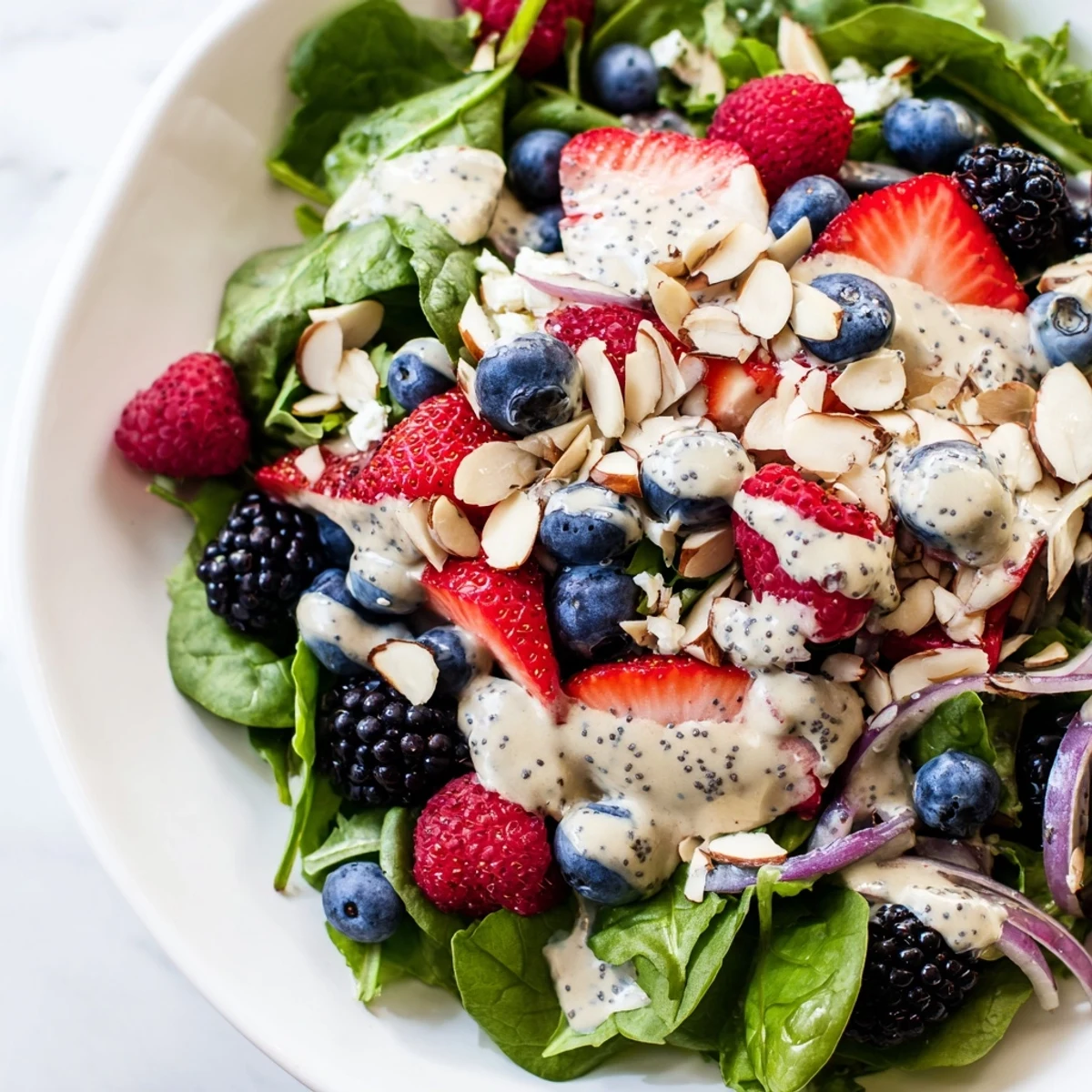 Bright summer Berry Salad with Poppy Seed Dressing served over crisp baby greens, topped with fresh strawberries and blueberries.  
