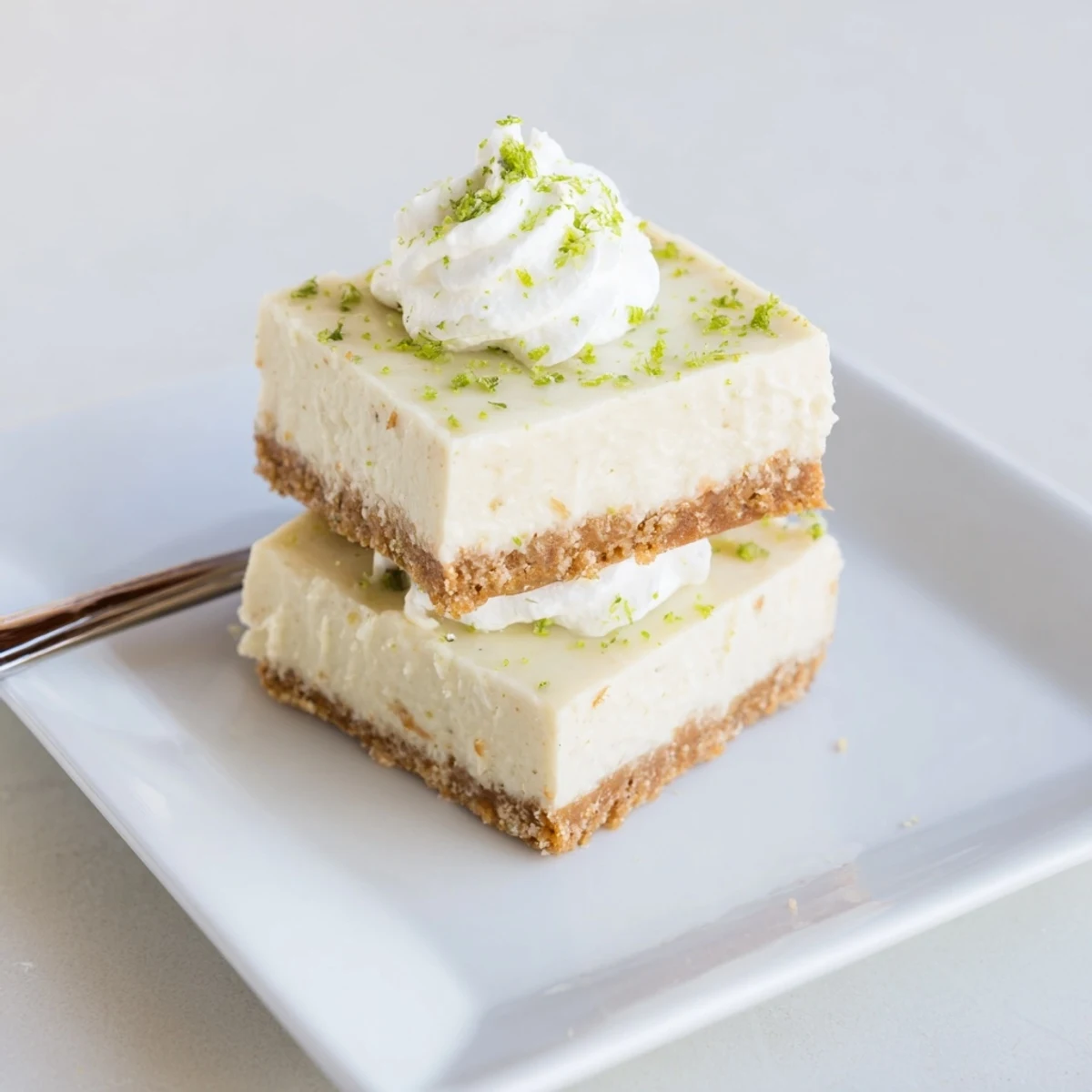 Sweet and tangy Key Lime Pie Bars with a creamy filling, served on a white plate.