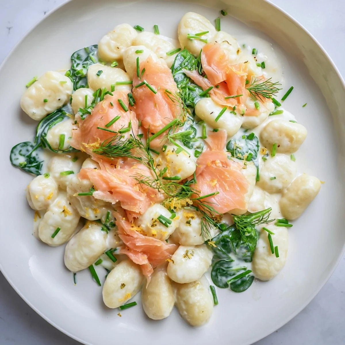 Healthy Smoked Salmon Gnocchi plated with a fork, garnished with dill and chives for a fresh weeknight dinner.