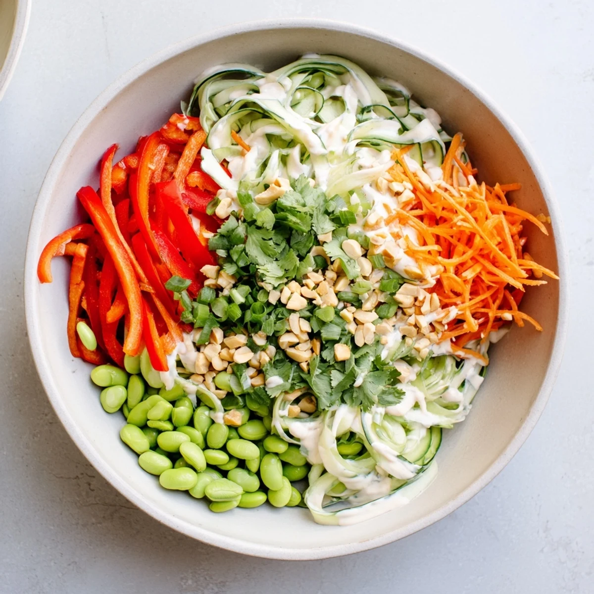 Vibrant Creamy Asian Cucumber Bowl with crunchy veggies and creamy dressing, served fresh and chilled.
