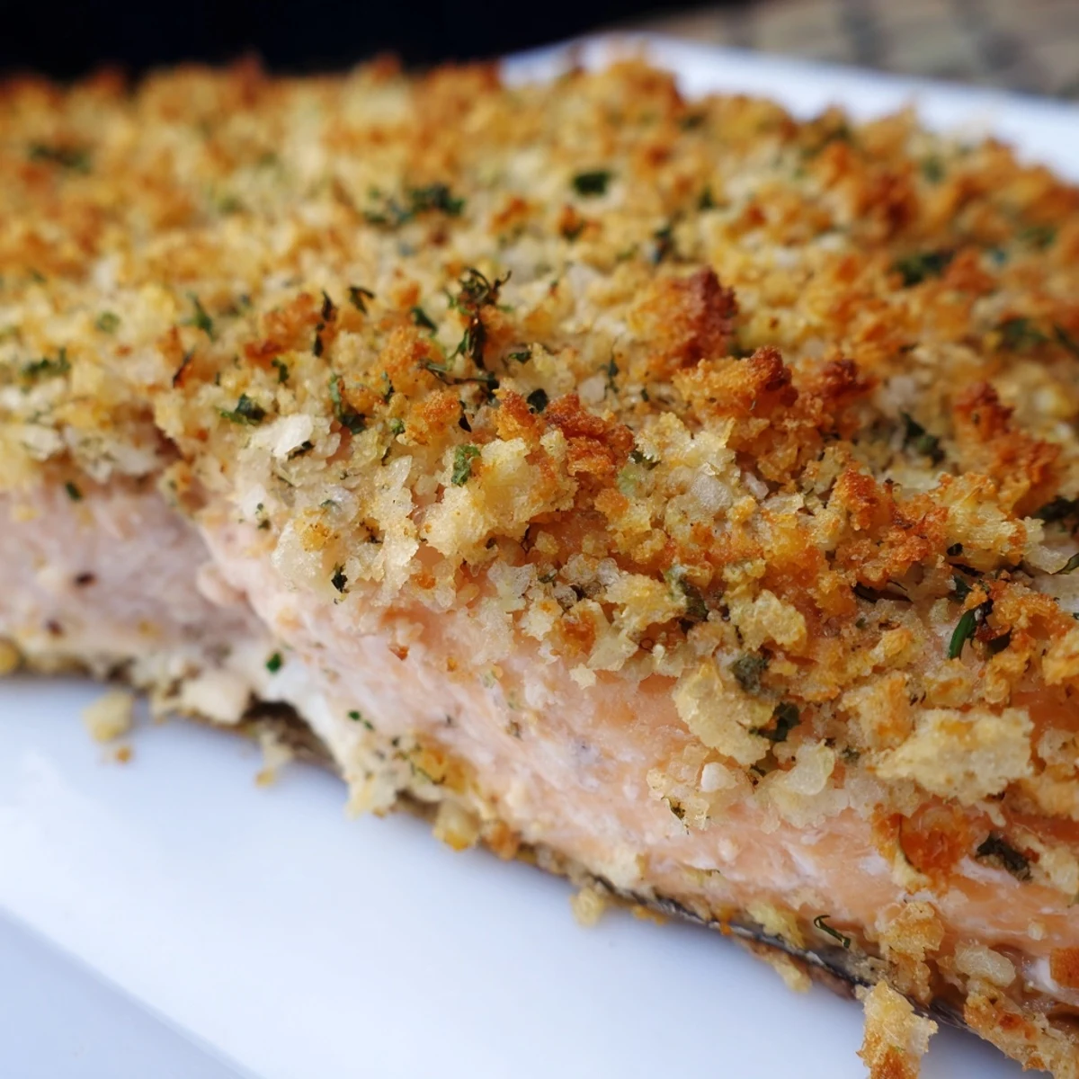 Freshly baked Irresistibly Crispy Parmesan Salmon fillets with a golden, crunchy topping and lemon wedges on a baking sheet.