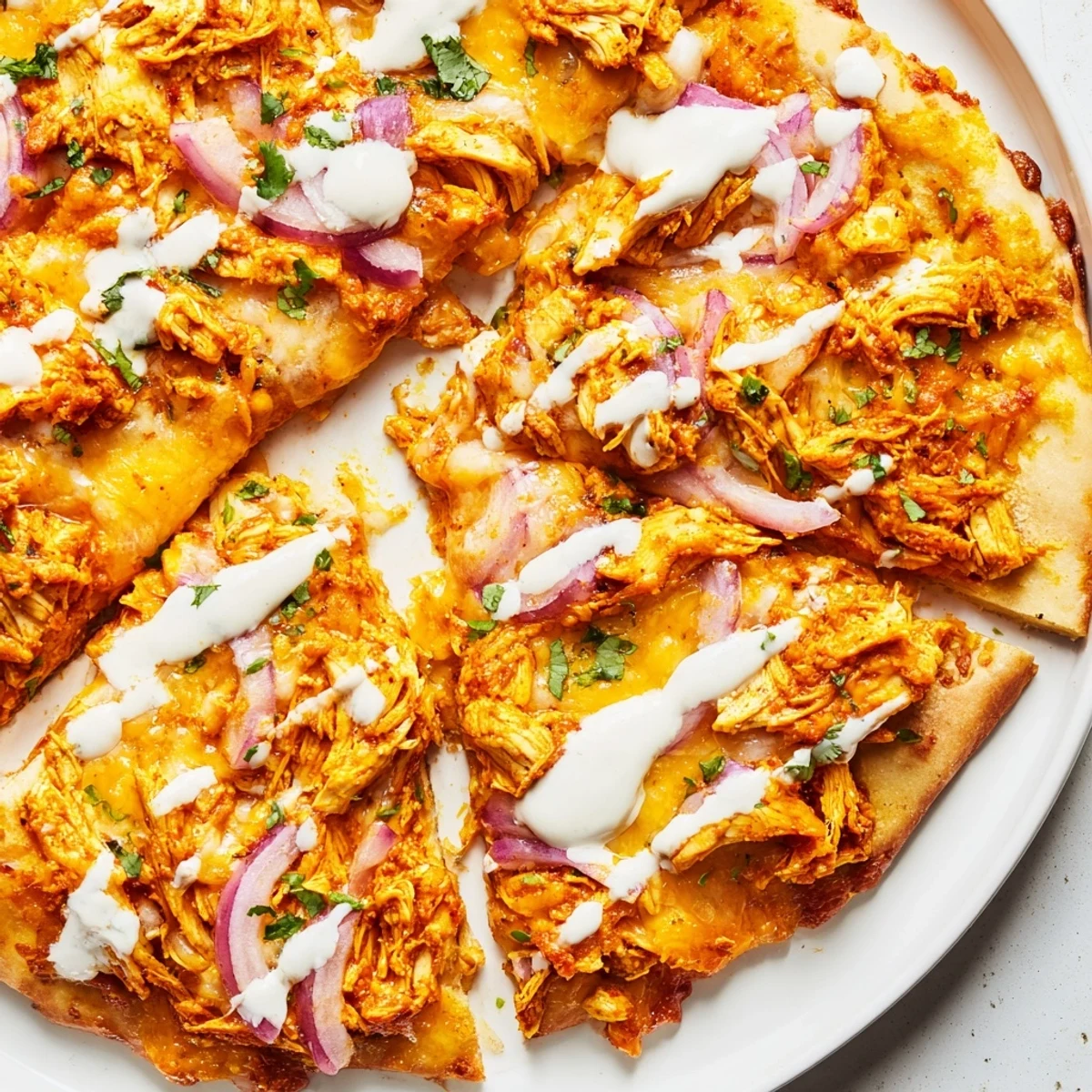 Sizzling Bold Buffalo Chicken Pizza with spicy chicken, creamy ranch drizzle, and fresh scallions on top.