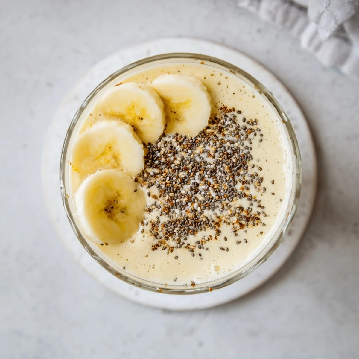 Protein-packed Greek yogurt banana smoothie garnished with cinnamon and chia seeds in clear glasses
