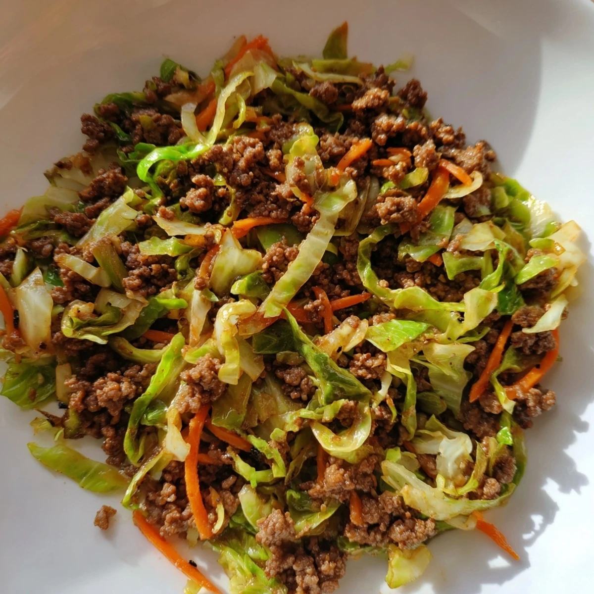 Plate of gluten-free ground beef and cabbage stir fry featuring tender meat and colorful shredded vegetables