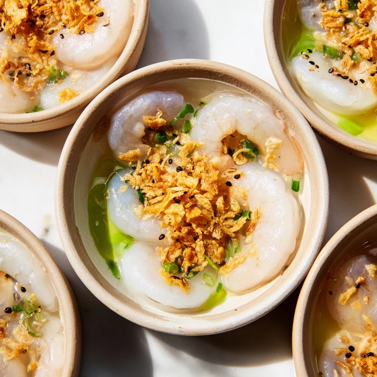 Delicate Vietnamese Banh Beo rice cakes garnished with crispy shallots and bright scallions