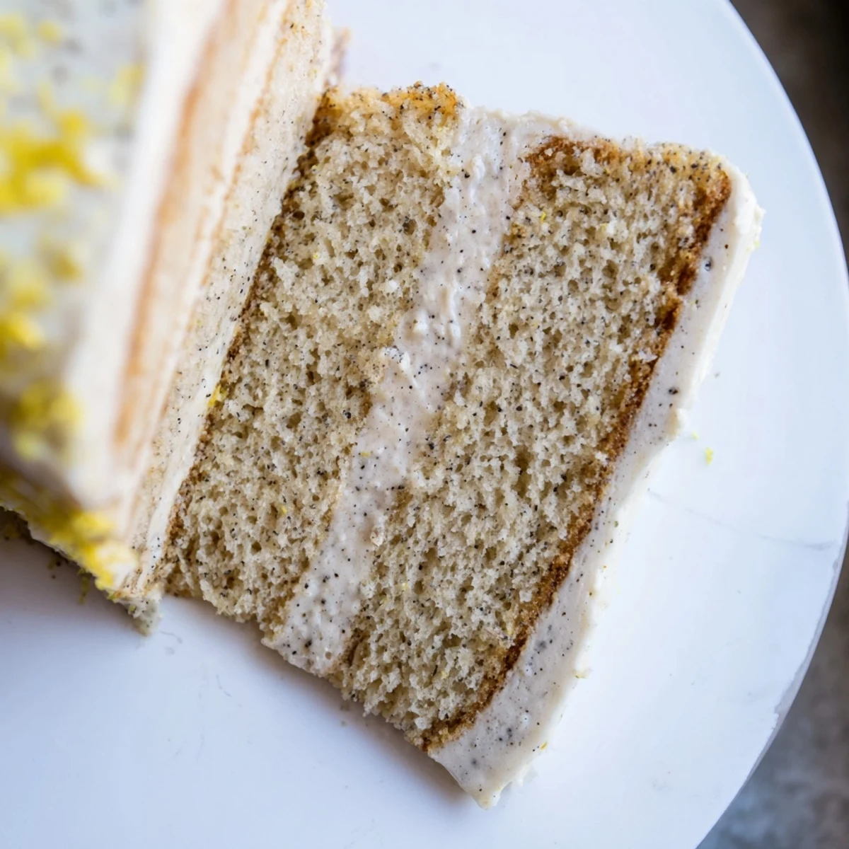 Three-layer London Fog cake topped with vanilla frosting and garnished with lemon zest