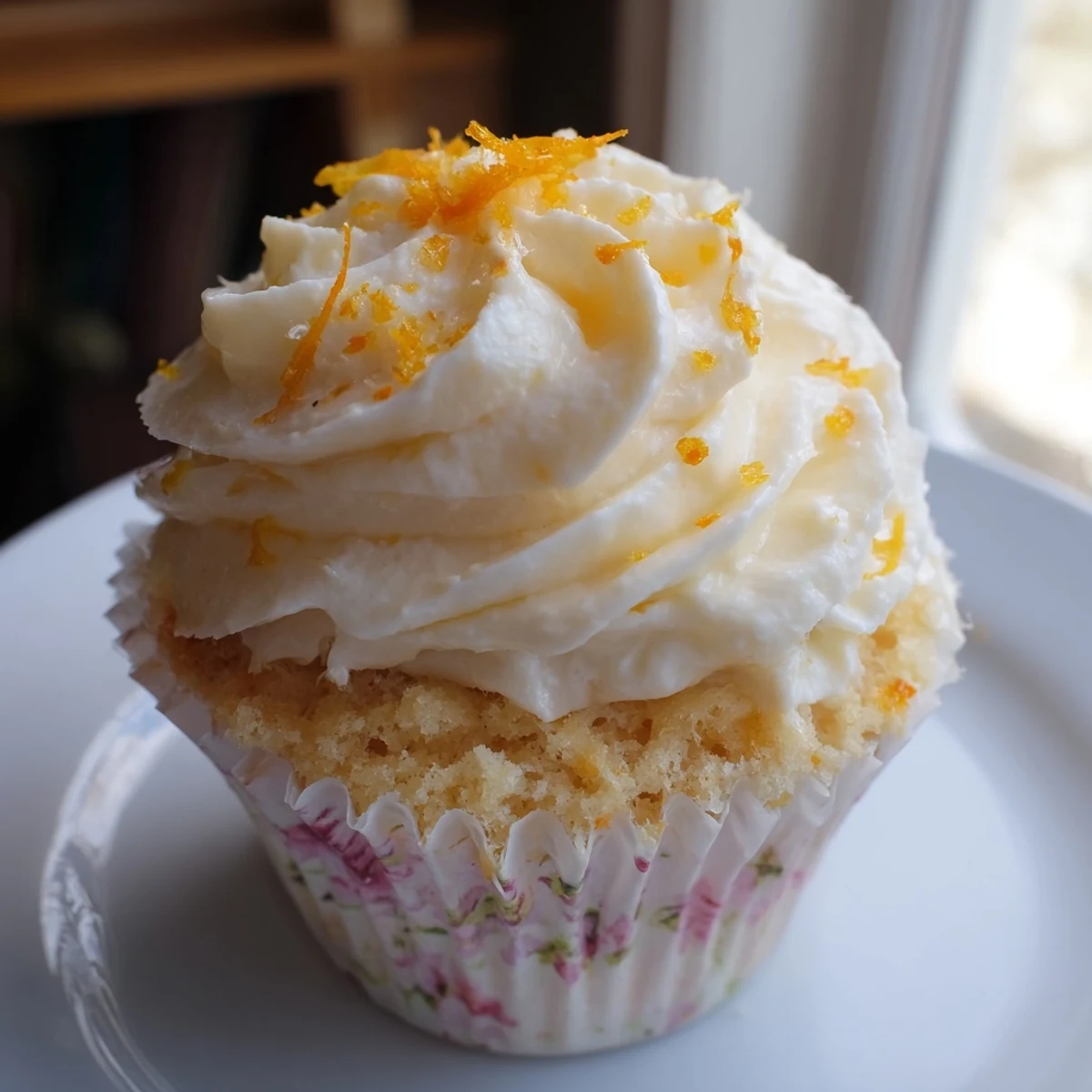 Golden orange blossom cupcakes with fluffy citrus frosting garnished with fresh orange zest