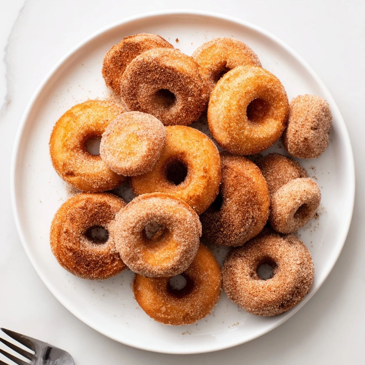 Warm fried donuts dusted with spiced sugar, featuring the classic pumpkin spice biscuit donuts recipe.