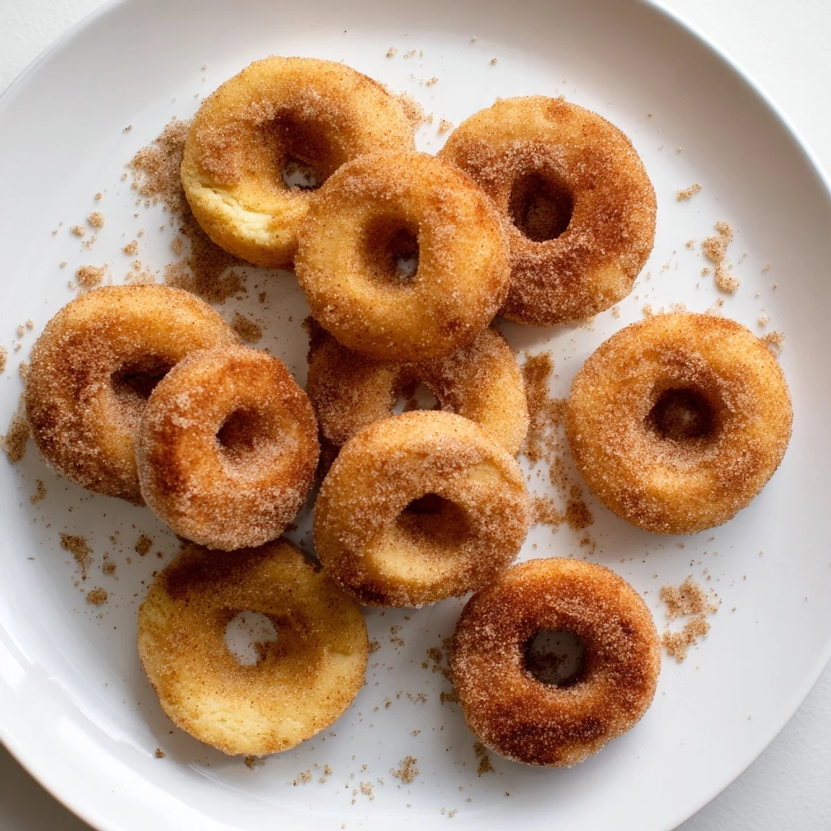 Fluffy pumpkin spice biscuit donuts with holes arranged on a wire cooling rack.