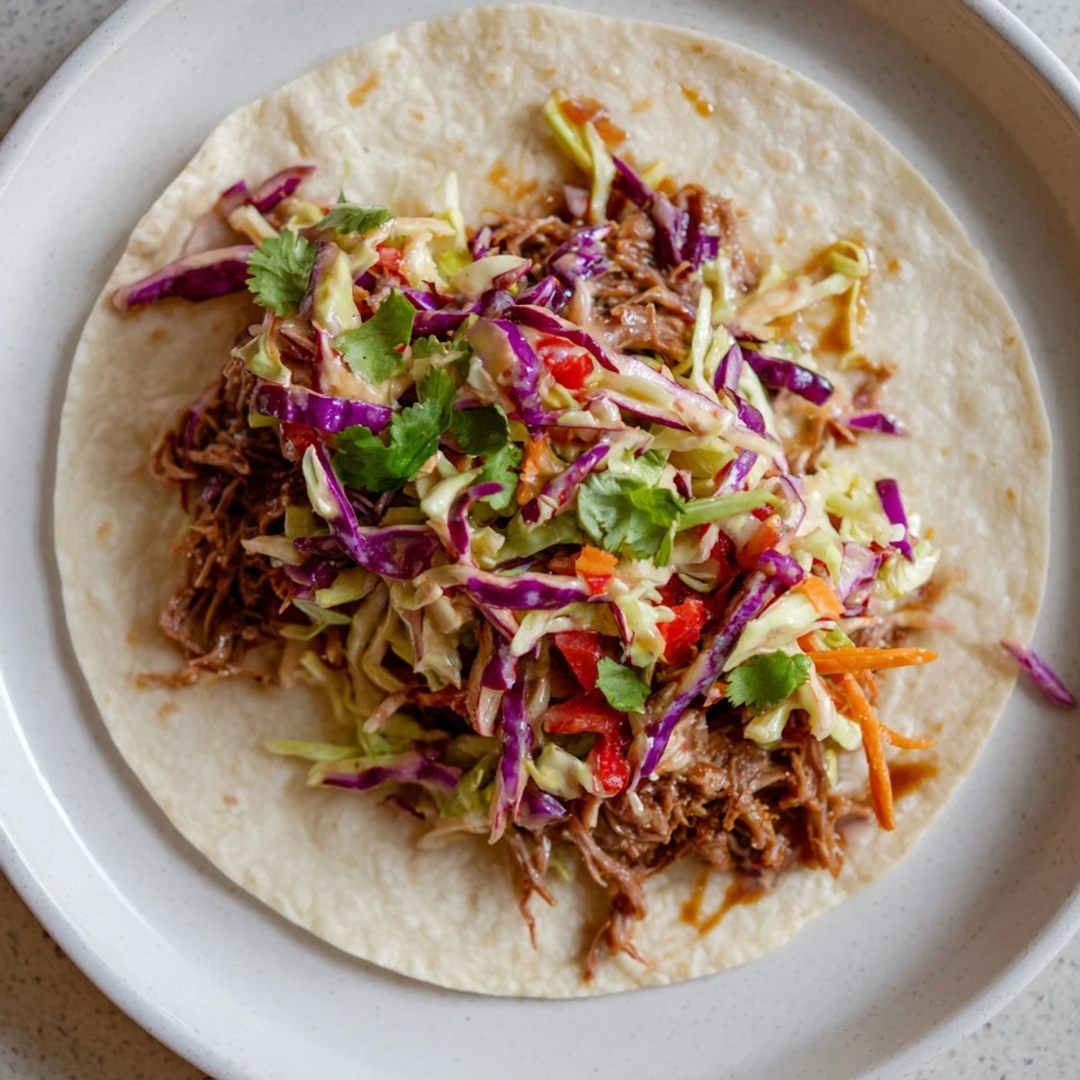 Flour tortilla filled with smoky sweet beef chuck and vibrant cabbage slaw for easy American dinner