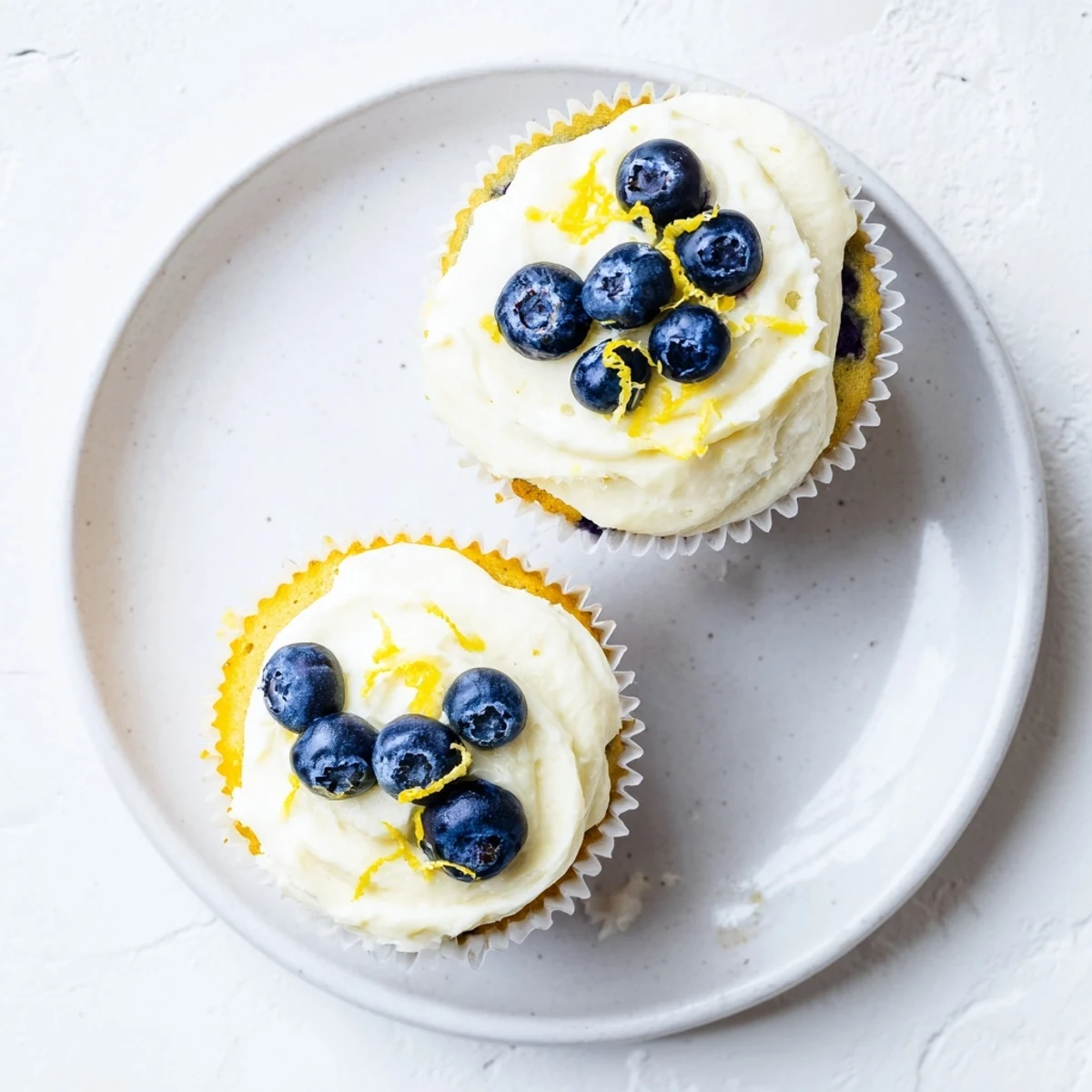 Summer dessert of lemon blueberry cupcakes with fresh berries swirled into golden sponge cake