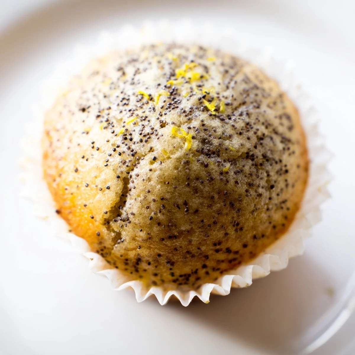 Golden lemon poppy seed muffins with domed tops fresh from the oven on a wire cooling rack