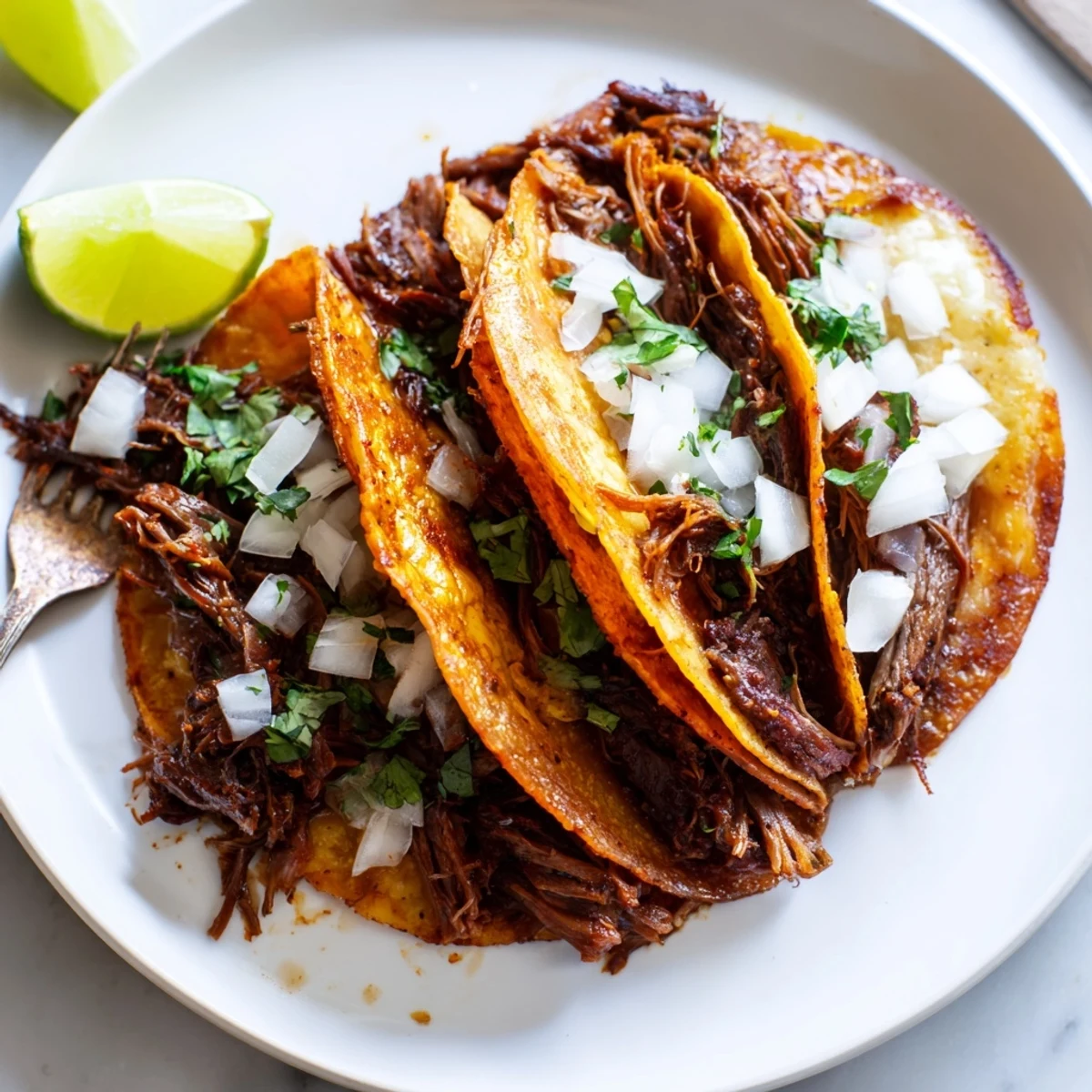 Tender shredded beef nestled in golden fried tortillas for slow cooker birria tacos