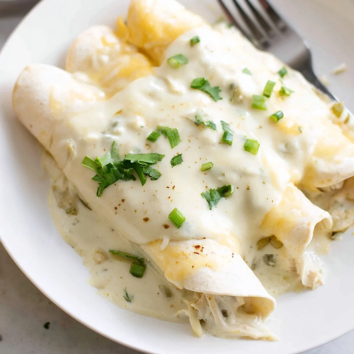 Melted Monterey Jack crowns Creamy White Chicken Enchiladas, steam rising temptingly.