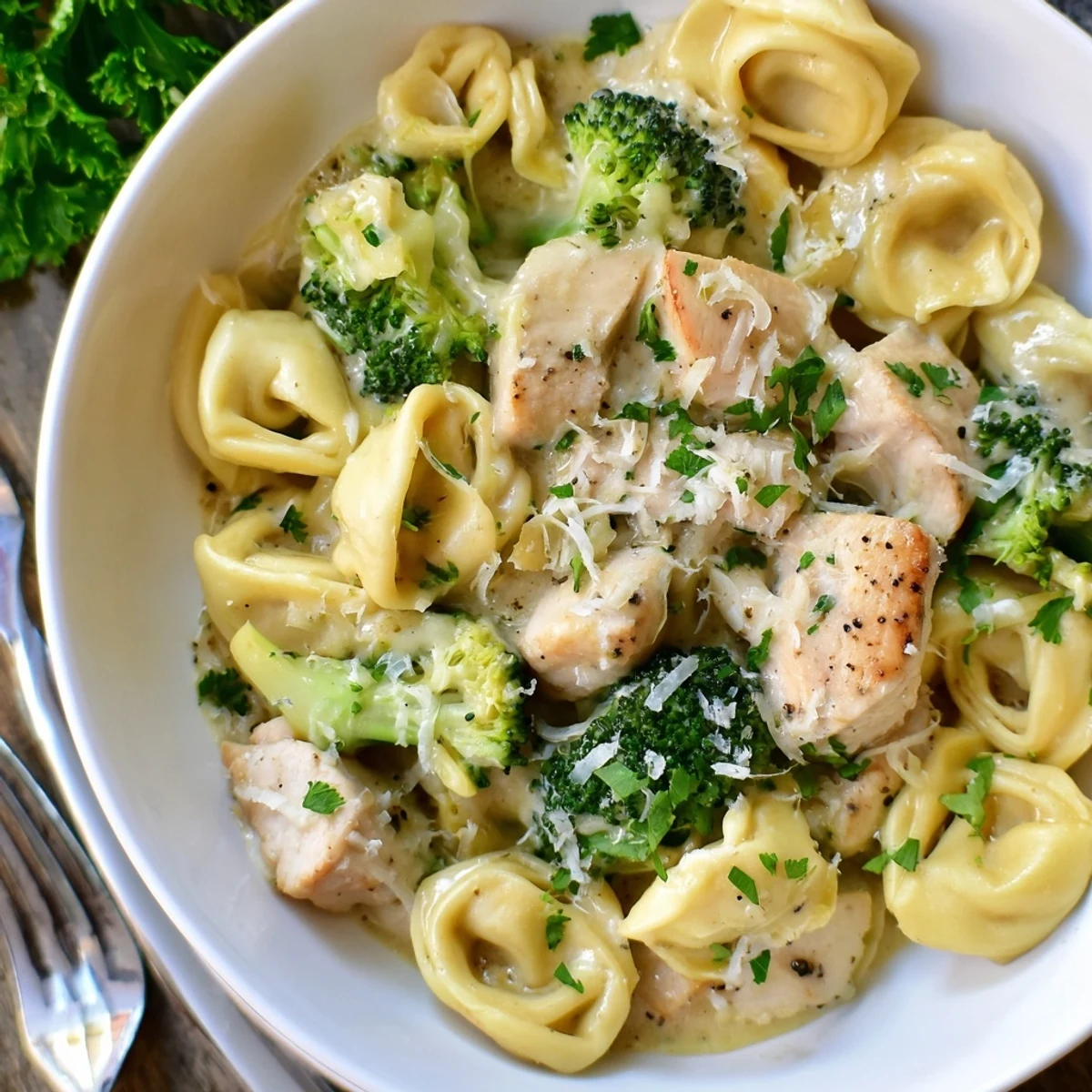 Creamy Garlic Parmesan Tortellini Chicken Broccoli Recipe plated steaming, garnished with parsley