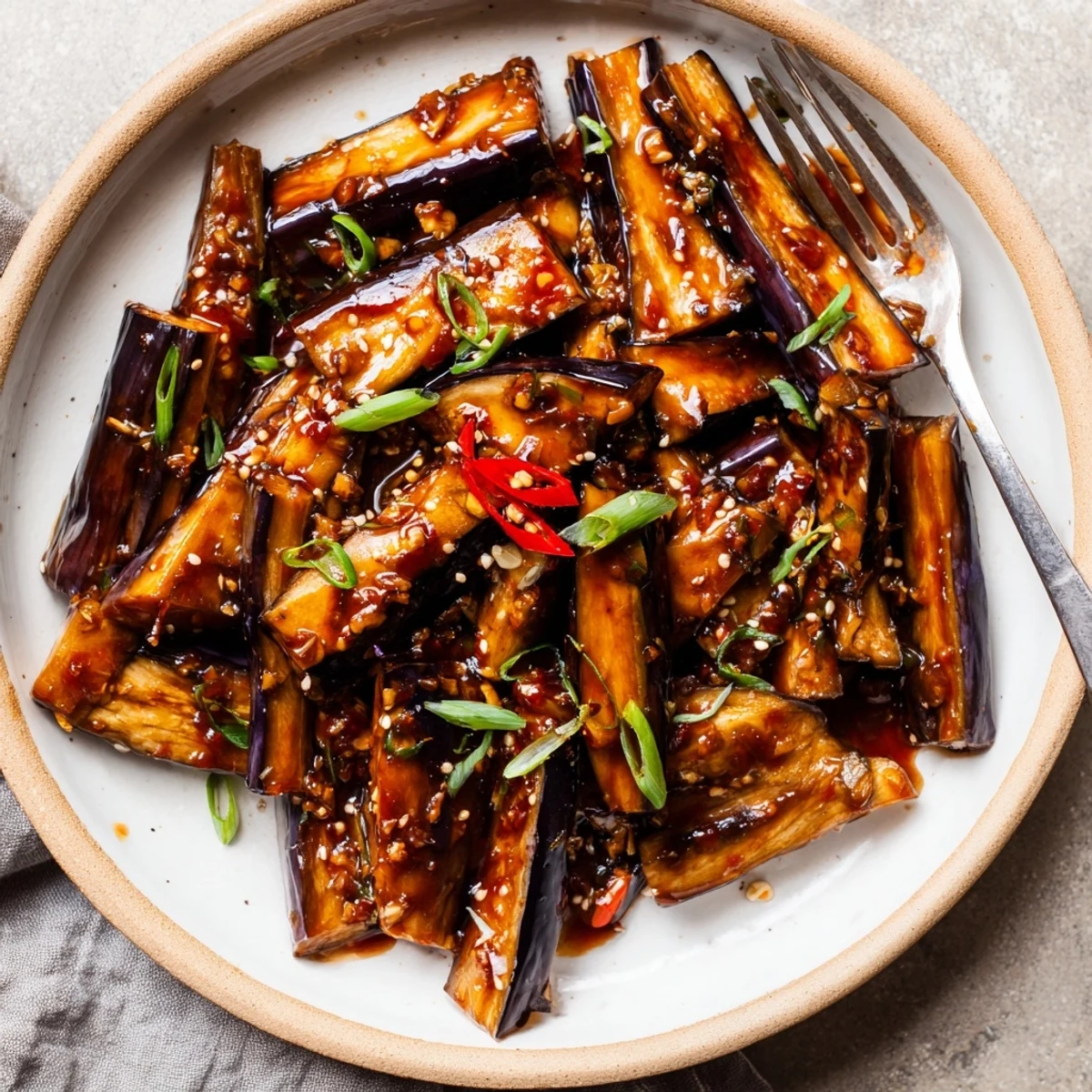 Sichuan Style Braised Aubergines spooned over steamed jasmine rice, fragrant and saucy.