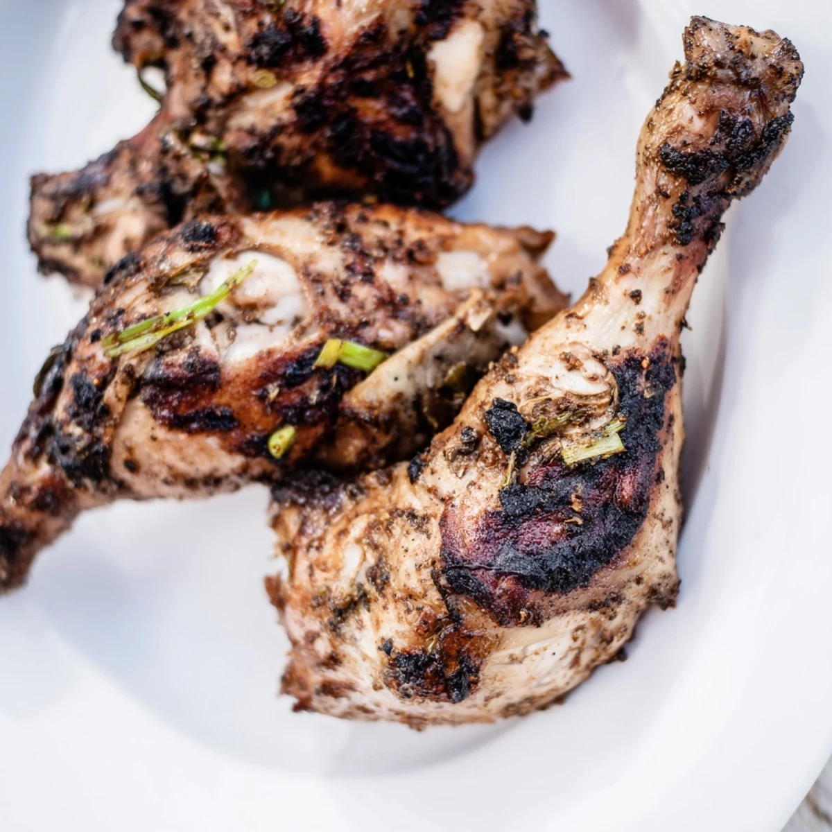 Plate of tender Jamaican Jerk Chicken served alongside steamed rice and peas with caramelized edges