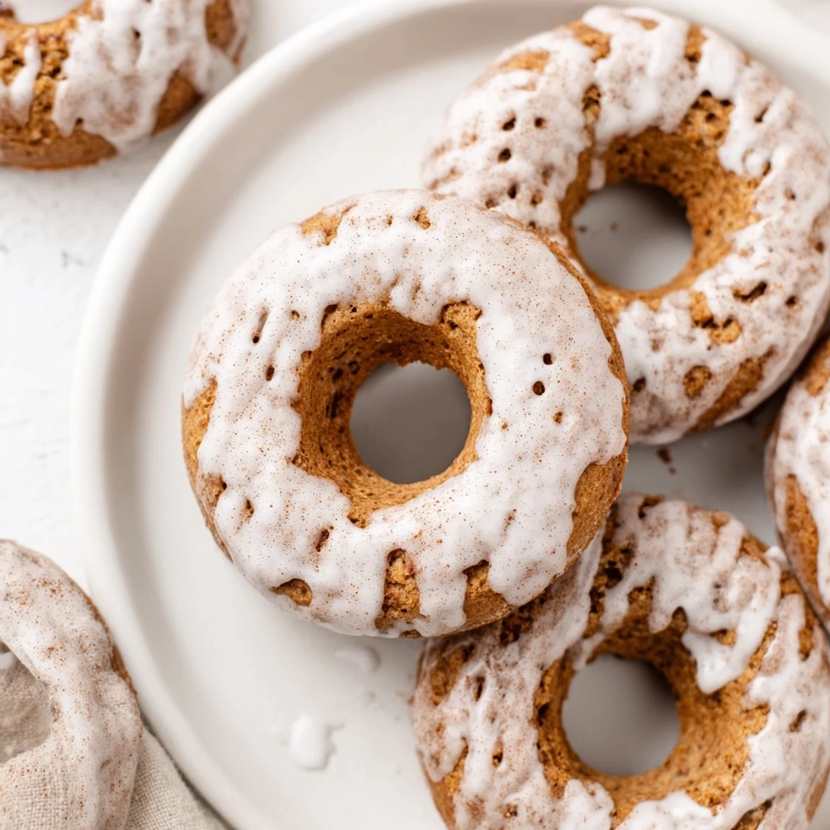 Golden brown banana bread donuts topped with sweet powdered sugar glaze drizzle