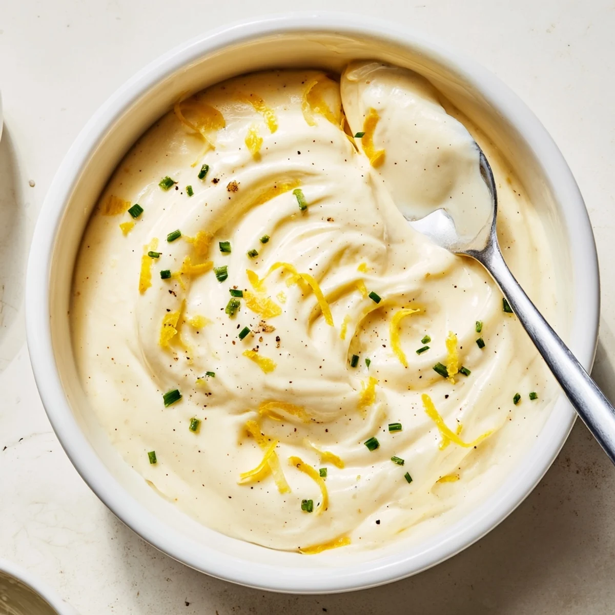 Creamy Tangy Sauce spooned onto a sandwich, bright, smooth, zesty and refreshing