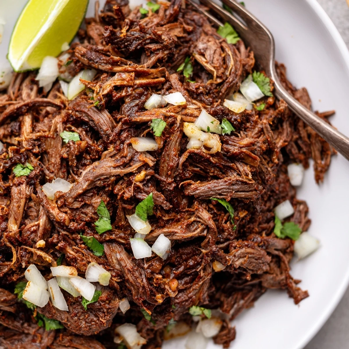 Slow Cooker Beef Barbacoa braised eight hours, fork tender, smoky, served with lime.